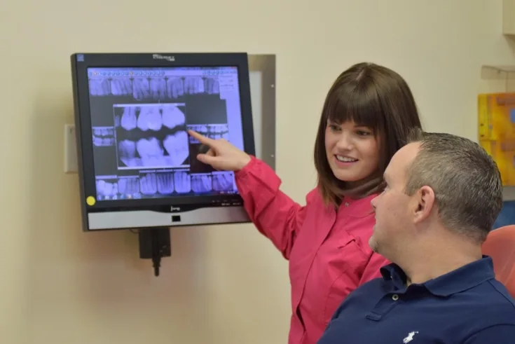 Dentist reviewing digital x-rays with an adult patient