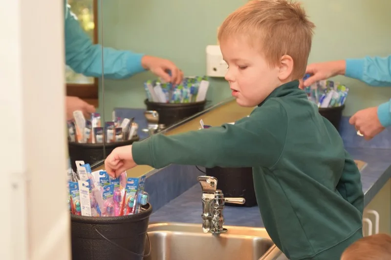 A young patient picking out a new toothbrush at Norwell Pediatric Dentistry